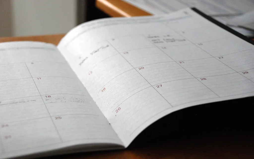 open monthly planner on wooden desk