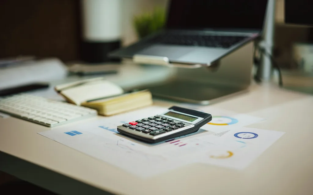 a calculator sitting on top of a table next to a laptop